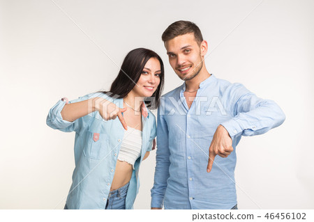 People and gesture concept - young pretty woman and handsome man pointing down over white background People and gesture concept - young pretty woman and handsome man pointing down over white background 46456102