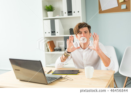 Business, fun and joke concept - young man blowing bubble of chewing gum in office 46456844