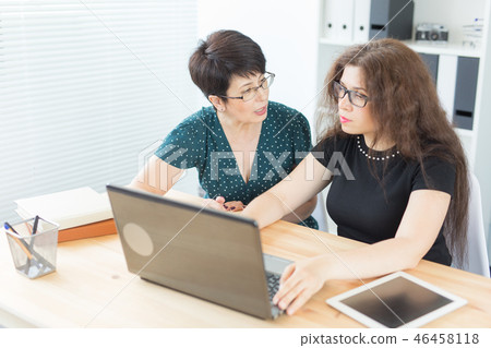 Office, business people and graphic designer concept - Women sitting and discussing ideas at the Office, business people and graphic designer concept - Women sitting and discussing ideas at the 46458118