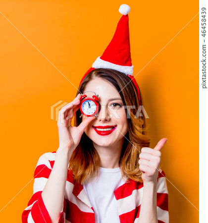 woman in Santa Claus hat with little alarm clock woman in Santa Claus hat with little alarm clock 46458439
