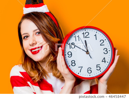 Smiling woman in Santa Claus hat with clock 46458447