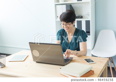 Business people and technology concept - Middle age woman is working at the office with laptop Business people and technology concept - Middle age woman is working at the office with laptop 46459238