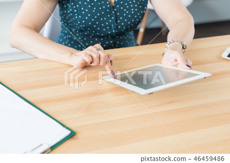 Business, technology and people concept - Close up of female hands holding a tablet on office table Business, technology and people concept - Close up of female hands holding a tablet on office table 46459486