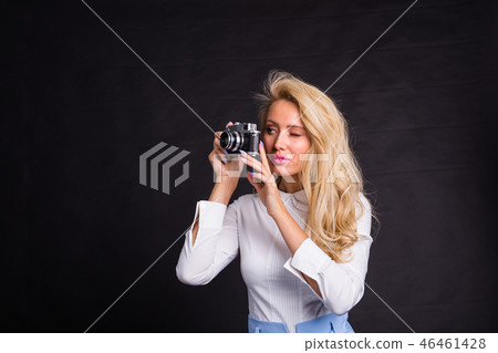 Photographing, fashion and people concept - young blonde woman making a photo from something on Photographing, fashion and people concept - young blonde woman making a photo from something on 46461428
