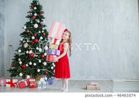little girl opens Christmas presents new year tree decoration 46463874