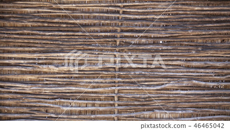 Wattle fence of dry twigs in the background. Wattle fence of dry twigs in the background. 46465042