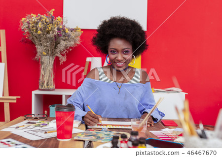 Cheerful designer wearing massive earrings smiling broadly 46467670