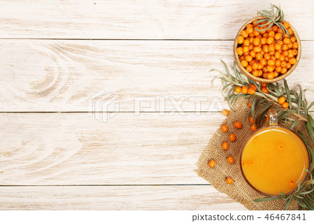 Sea buckthorn juice or tea with berries on a white wooden background with copy space for your text Sea buckthorn juice or tea with berries on a white wooden background with copy space for your text 46467841