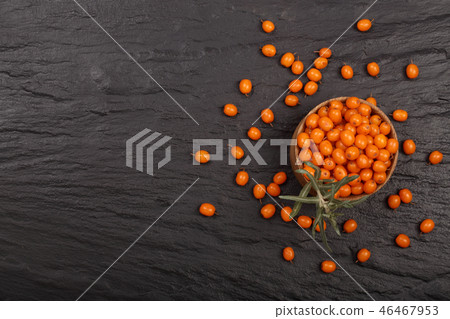 Sea buckthorn. Ripe fresh berries in bowl on black stone background with copy space for your text 46467953