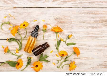 aromatherapy essential oil with marigold flowers on white background with copy space for your text aromatherapy essential oil with marigold flowers on white background with copy space for your text 46468359