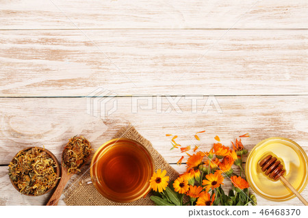 Calendula tea with fresh and dried flowers on white wooden background with copy space for your text Calendula tea with fresh and dried flowers on white wooden background with copy space for your text 46468370