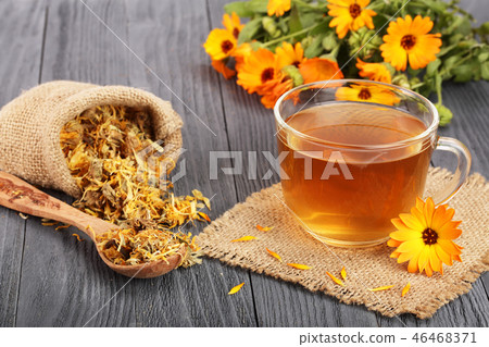 Calendula tea with fresh and dried flowers on black wooden background 46468371