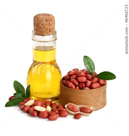 peanut oil in a glass bottle with peanuts in bowl peanut oil in a glass bottle with peanuts in bowl 46468725