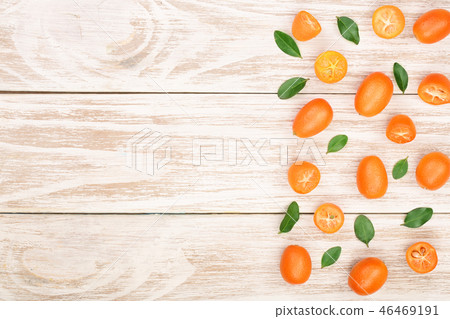 Cumquat or kumquat with leaf on white wooden background with copy space for your text. Top view Cumquat or kumquat with leaf on white wooden background with copy space for your text. Top view 46469191
