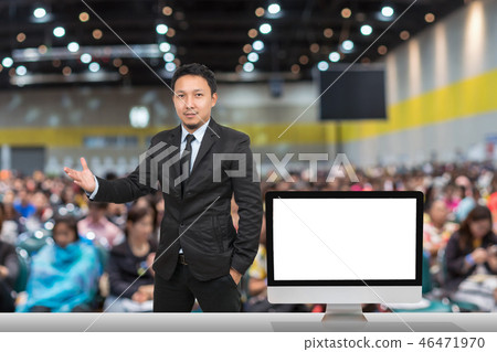 Businessman giving the knowledge with showing the white background on the computer screen over blurred photo of attendee in Exhibition Center,Business Seminar concept Businessman giving the knowledge with showing the white background on the computer screen over blurred photo of attendee in Exhibition Center,Business Seminar concept 46471970