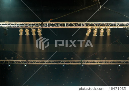 Luminous rays from concert lighting against a dark background over the projector screen, musical instrument concept 46471985