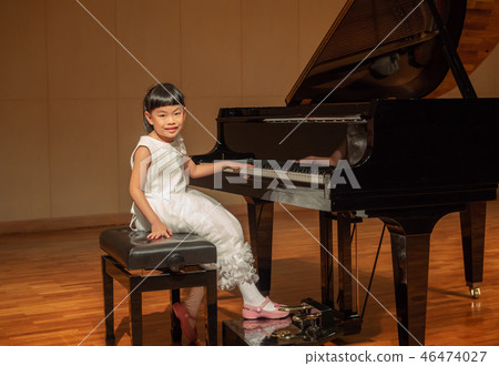 Little girl in white dress on stage with piano Little girl in white dress on stage with piano 46474027
