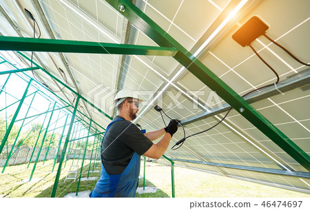 Worker installing solar panels during sunny day Worker installing solar panels during sunny day 46474697