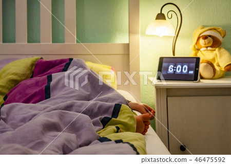 Little girl sleeping in bed - Alarm clock at 6 am in the morning. Little girl sleeping in bed - Alarm clock at 6 am in the morning. 46475592