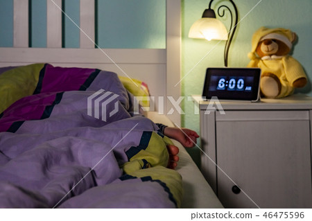 Little girl sleeping in bed - Alarm clock at 6 am in the morning. Little girl sleeping in bed - Alarm clock at 6 am in the morning. 46475596
