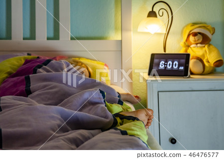 Little girl sleeping in bed - Alarm clock at 6 am in the morning. Little girl sleeping in bed - Alarm clock at 6 am in the morning. 46476577