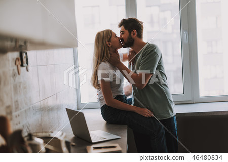 Lovely kissing couple spending time at home in kitchen 46480834