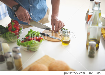 Man chopping garlic with knife on cutting board Man chopping garlic with knife on cutting board 46480853