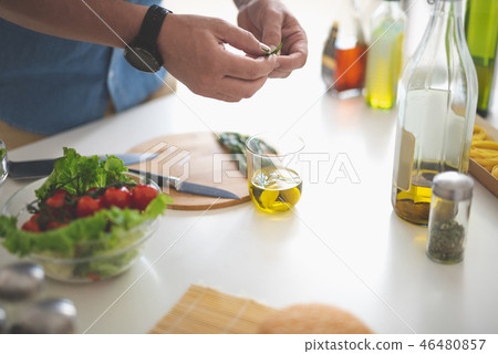 Man preparing herbs for delicious vegetable salad Man preparing herbs for delicious vegetable salad 46480857