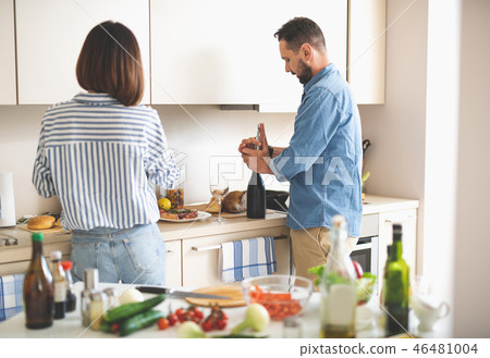 Beautiful couple preparing for romantic dinner in kitchen 46481004