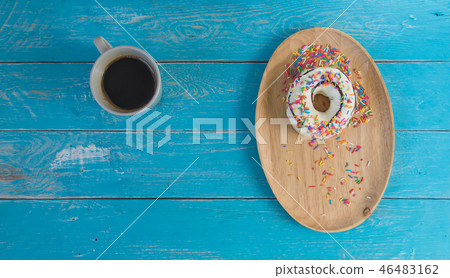 Donut in wooden tray and black coffee. Donut in wooden tray and black coffee. 46483162