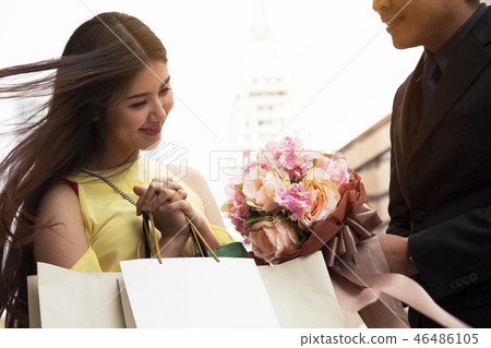 The young man gives flowers to the beloved girl. 46486105