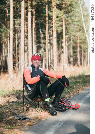 Training an athlete on the roller skaters. Biathlon ride on the roller skis with ski poles, in the 46487520