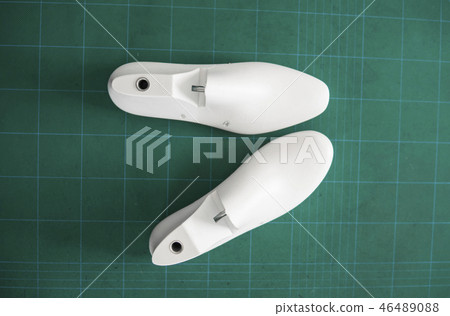 Two white plastic last shoe on rubber secondary cut cutting mat, The equipment used for shoe design. 46489088