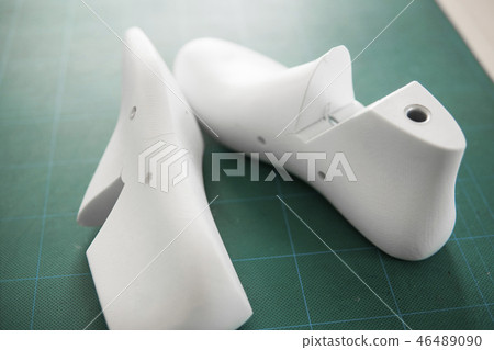 Two white plastic last shoe on rubber secondary cut cutting mat, The equipment used for shoe design. 46489090