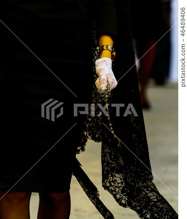 Rosary held by a woman in a black dress Rosary held by a woman in a black dress 46489406