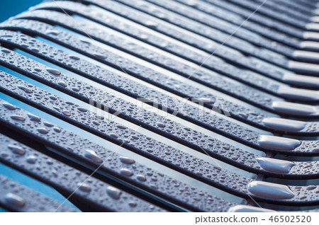 Closeup od rain drops on metallic bench Closeup od rain drops on metallic bench 46502520