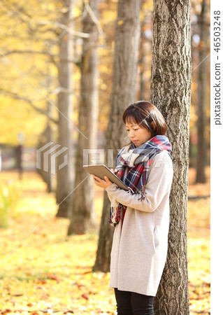 Middle lady enjoying autumn leaves Middle lady enjoying autumn leaves 46503248