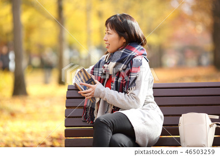Middle lady enjoying autumn leaves 46503259