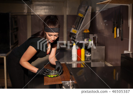 woman chef prepares delicious fresh burgers in the kitchen at restaurant woman chef prepares delicious fresh burgers in the kitchen at restaurant 46505387