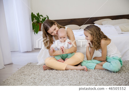 three girls sisters in the morning in the bedroom on the bed play three girls sisters in the morning in the bedroom on the bed play 46505552