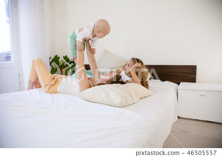 three girls sisters in the morning in the bedroom on the bed play 46505557