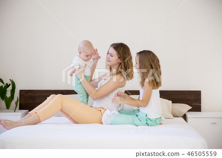 three girls sisters in the morning in the bedroom on the bed play 46505559