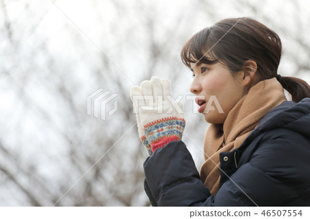 A woman warming her hands A woman warming her hands 46507554