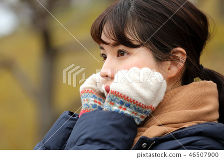 A woman warming her hands A woman warming her hands 46507900