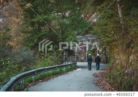 two workers walk on mountain road two workers walk on mountain road 46508317
