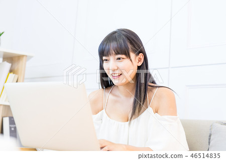 坐在地面上的一名婦女使用的手寫電動風扇。爬行的生活方式。爬行婦女的常規購買，平行使用信貸協議。 46514835