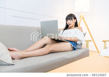 坐在地面上的一名婦女使用的手寫電動風扇。爬行的生活方式。爬行婦女的常規購買，平行使用信貸協議。 46514887