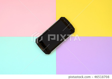 Black shock-proof smartphone lies on a pastel colored background Black shock-proof smartphone lies on a pastel colored background 46518708
