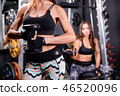 Sexy girl holding dumbbell at gym. 46520096