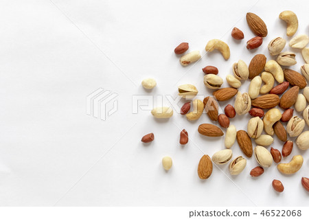 Assorted roasted and raw nuts scattered on white Assorted roasted and raw nuts scattered on white 46522068